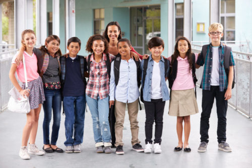 Teacher hanging out with group of elementary kids at school Teacher hanging out with group of elementary kids at school